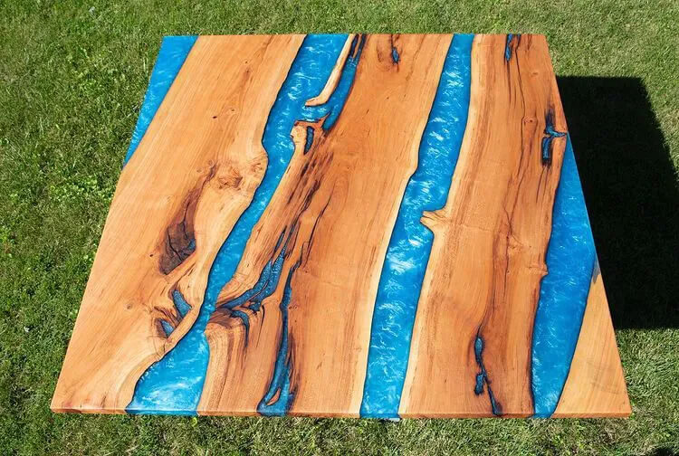 Blue tinted epoxy river table with multiple rivers