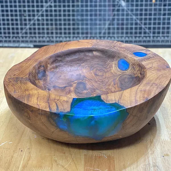 Wooden bowl with blue epoxy inlays