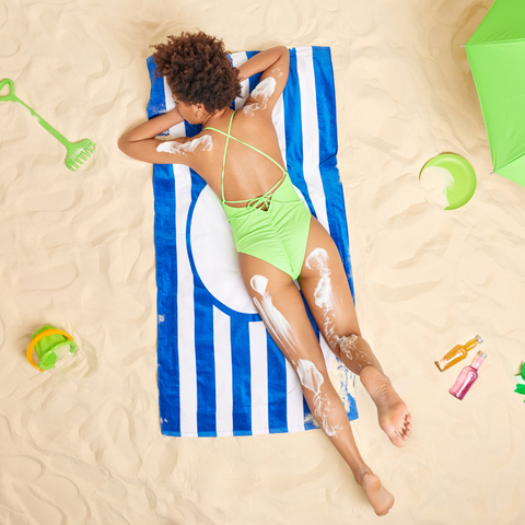 A woman on the beach, protected from the sun by body butter