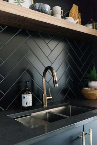 herringbone tile installation black gold kitchen