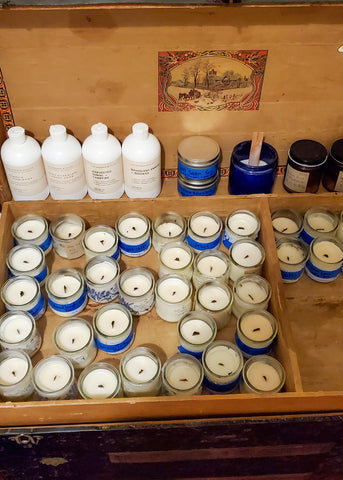 collection of fragrance tester candles in an antique steamer trunk