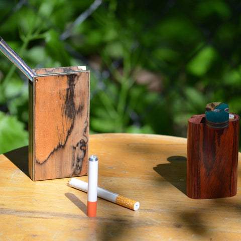Two - One hitter wooden dugouts on a wooden stool outside 