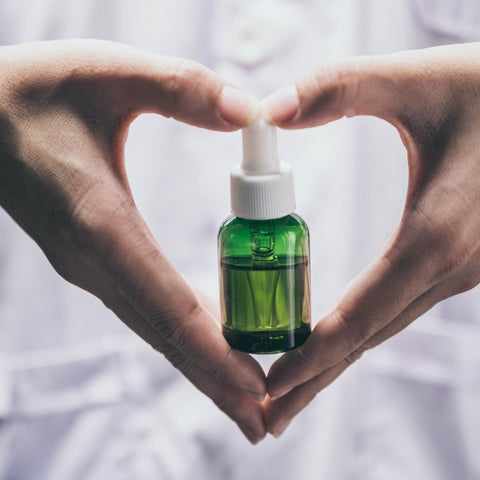 cbd green tincture held in the hands of someone 