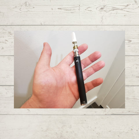 SteamCloud Evod battery with cartridge in hand with white wooden background 