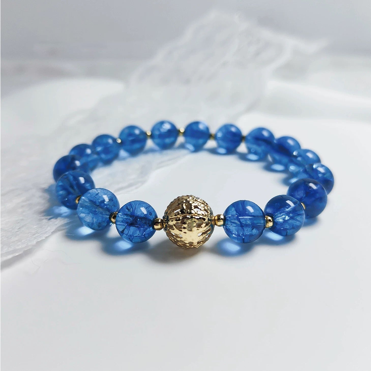 Maris Cordis Blue Crystal Bracelet with wave-shaped beads and silver anchor charm, shimmering like ocean waves. Designed for emotional healing and positive energy flow.