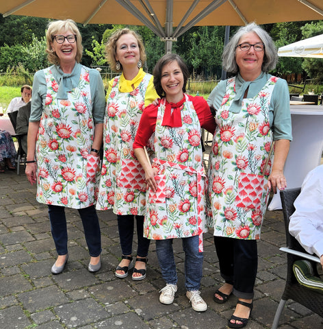 4 Damen in unterschiedlichem Alter mit der Küchenschürze Protea