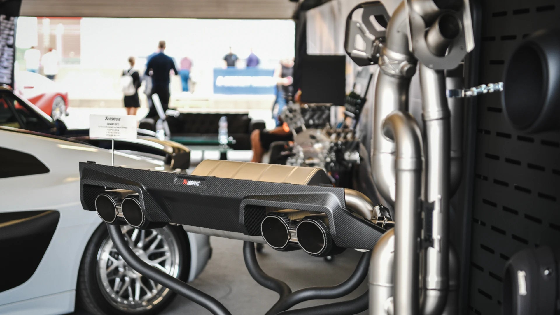 Akrapovic display showcasing BMW M2 G87 system at Secret Meet