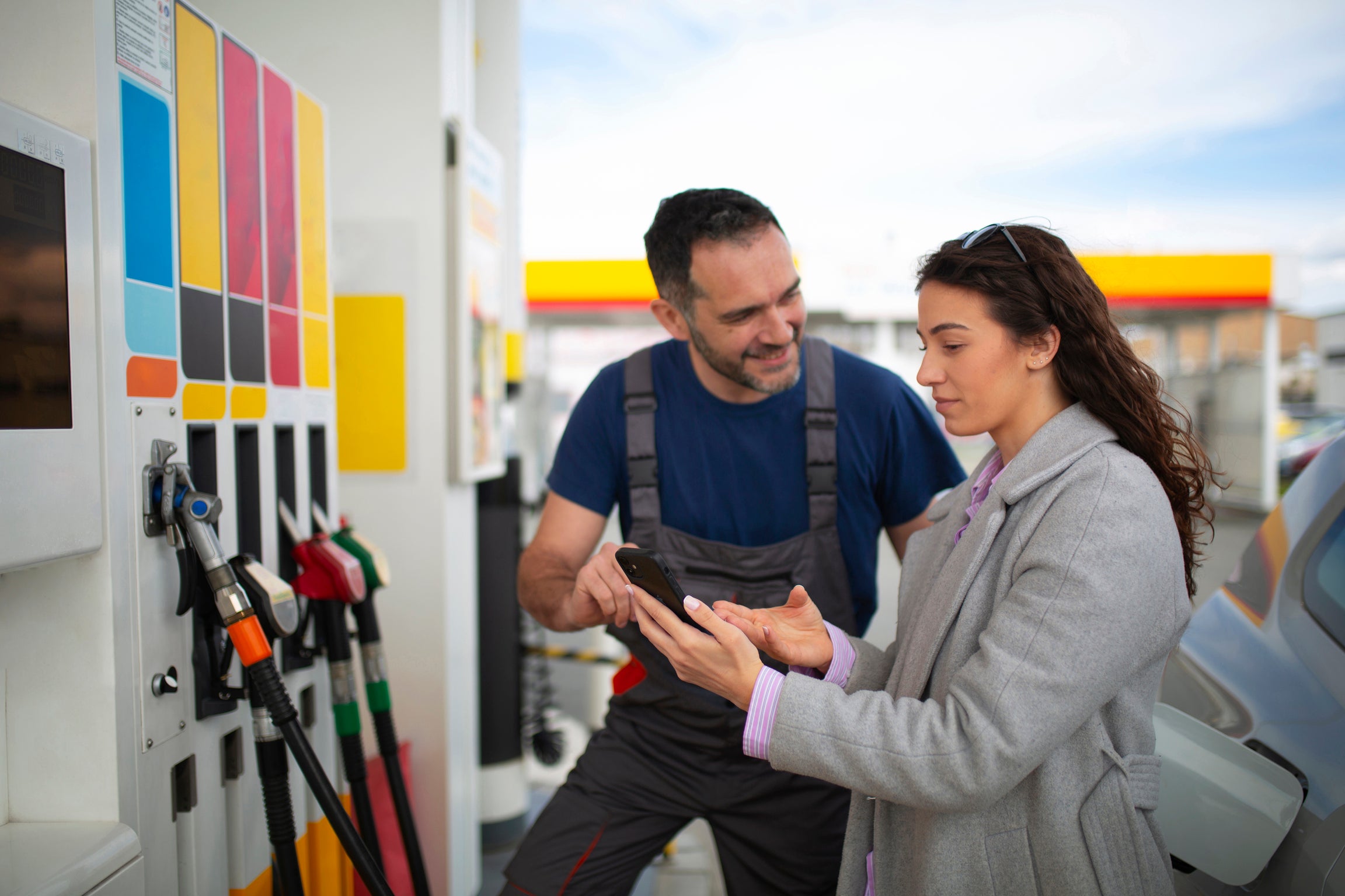a woman discussing the fuel quality standards with a gas station owner