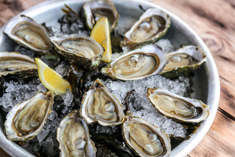 A plate of raw oysters served on a half shell