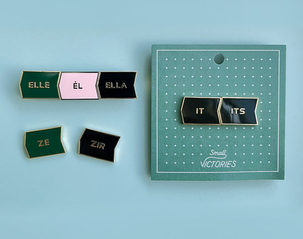 A photo of mix + match pronoun badges with elle, el, ella, it, its, ze, and zir pronouns