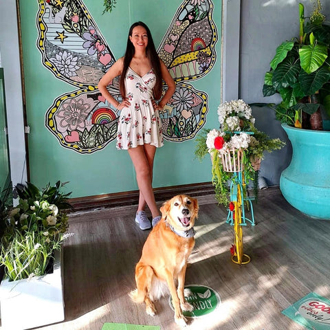 Zarina and her dog Chloe in front of a butterfly mural
