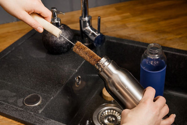 Cleaning metal water bottle with a bottle brush