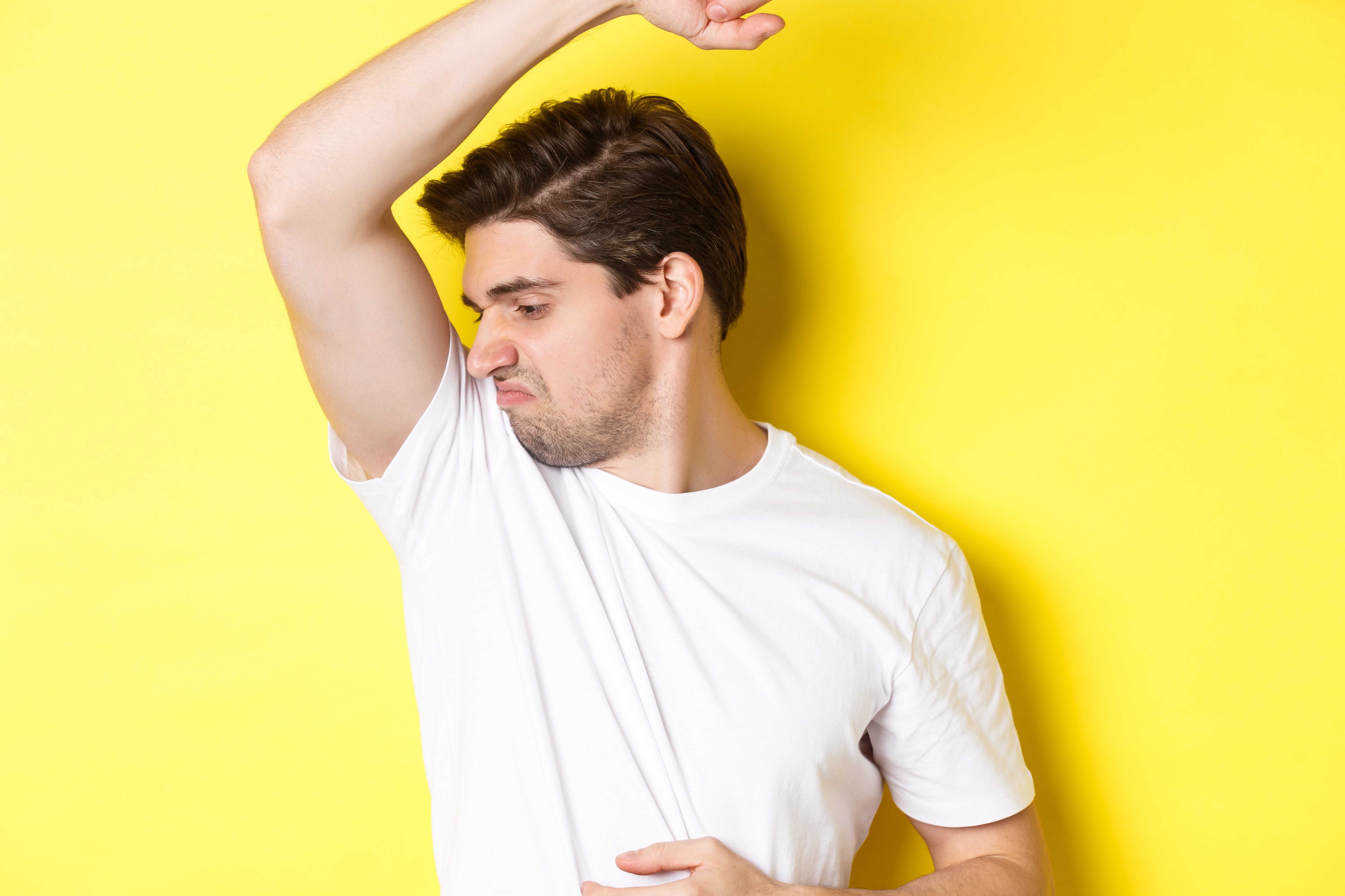 man-sweat-smelling-his-armpit-standing-white-t-shirt-grimacing-from-stinky-clothes.jpg__PID:3f0013eb-4566-41b7-b4cc-b3423adafde3
