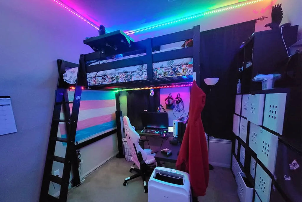 Schlafzimmer mit Computern und Klappbetten, installierten LED-Lichtleisten über der Decke und Beleuchtung in Regenbogenfarben.