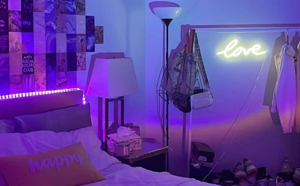 Das Schlafzimmer ist mit LED-Lichtleisten über dem Kopfteil und Neonlichtern an der Wand als violette Stimmungsbeleuchtung dekoriert.