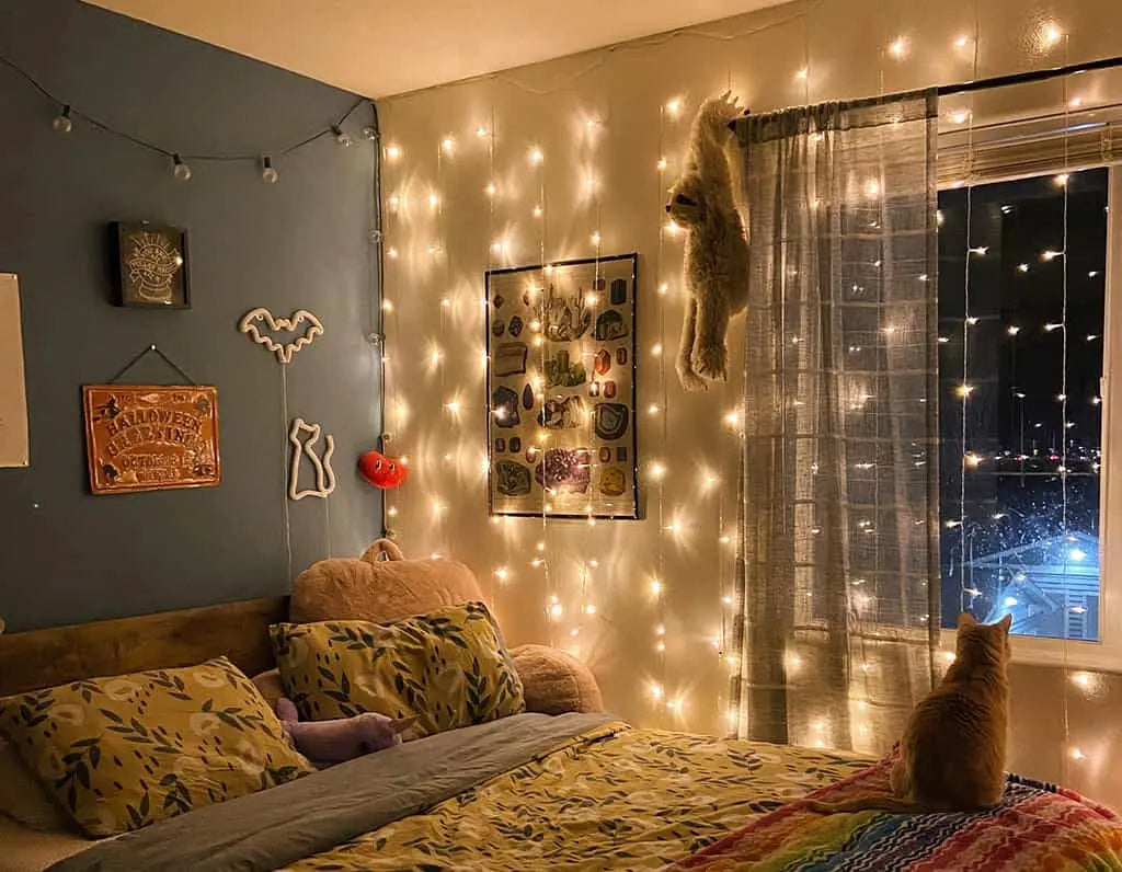 Die Wand neben dem Bett in der Nähe des Fensters im Schlafzimmer ist mit Lichterketten geschmückt, die für eine stimmungsvolle Beleuchtung sorgen.