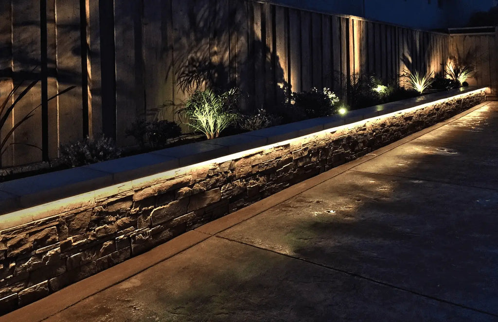 LED-Lichtleisten mit warmer Farbbeleuchtung heben die Landschaftsmerkmale des Gartens hervor.