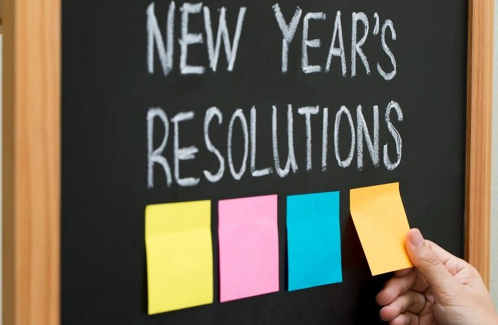 New Year's resolution written on the blackboard and four sticky notes attached.