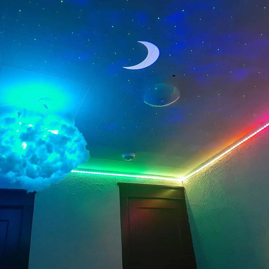 Dekorative Kombination zwischen den mondförmigen Sternenlichtern an der Decke und der Regenbogen-LED-Streifenbeleuchtung.