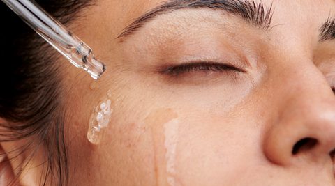 A woman applying beauty essence on her skin