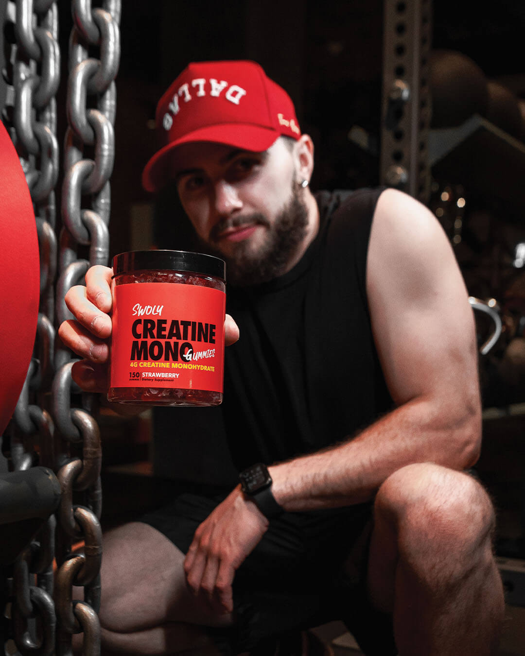 creatine gummies being held in a hand with gym weights in the background, swoly supplements, creatine monohydrate