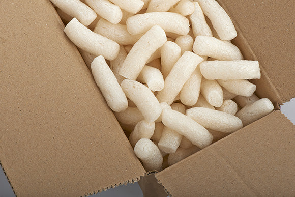 a close up of a box with yellow packing peanuts