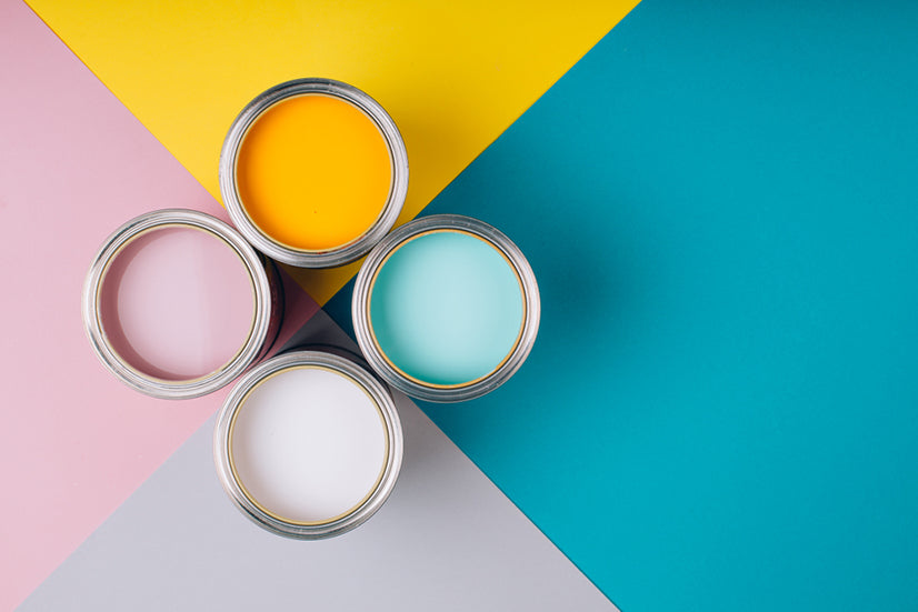 Four open cans of paint on bright backgrounds