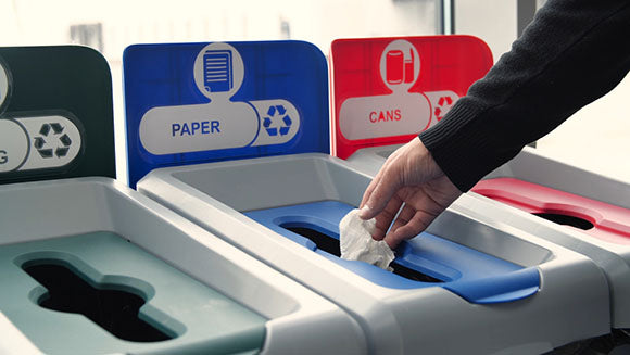 placing paper into recycling bin