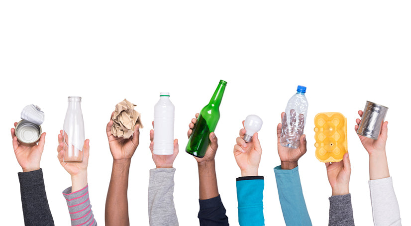 several people holding up different types of recyclables