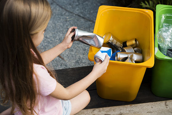 young girl recycling cans