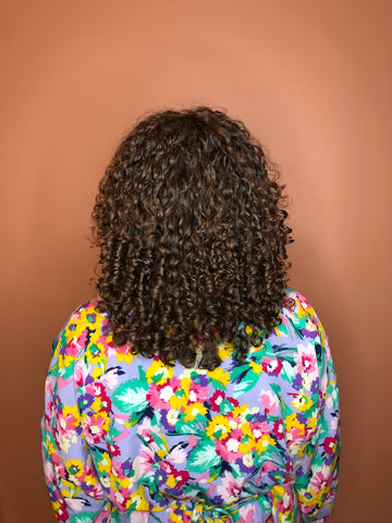 Photo avec une personne de dos et des cheveux bouclés 