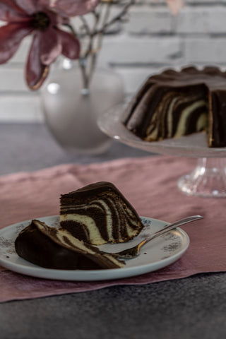 Du siehst einen Marmorkuchen mit Zebramuster und Schokoglasur