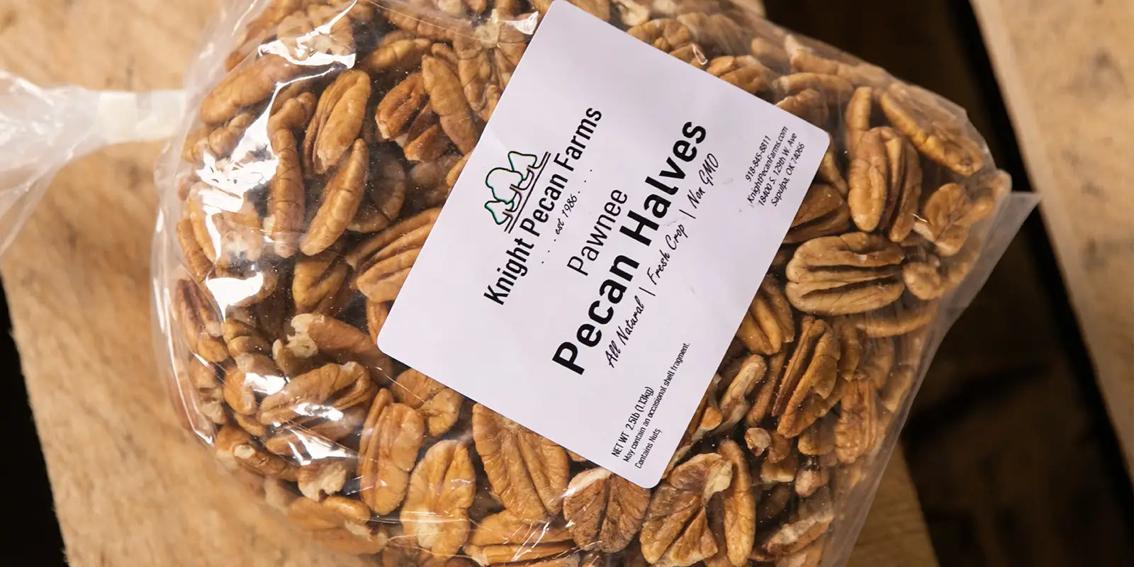 Bag of Pawnee Pecan Halves from Knight Pecan Farms on a wooden table