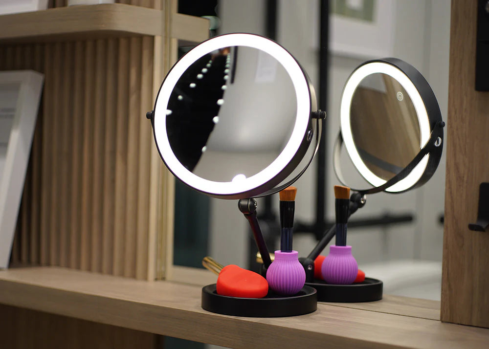 Adjustable mirror on a shelf with makeup grips