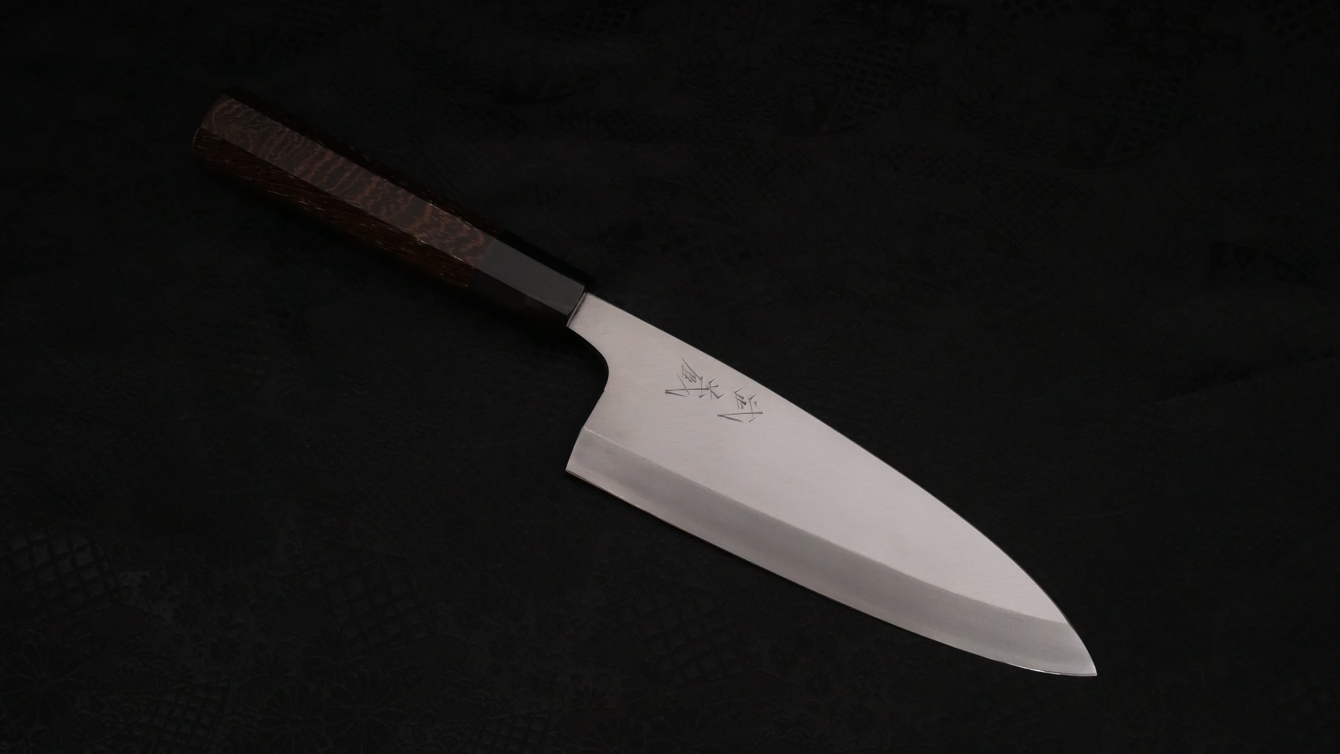 The Deba knife against a dark background.