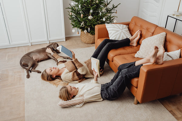 People With Their Legs On Sofa Reading - How To Sleep At Christmas