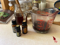 Elderberry syrup mixings of juice in a glass measuring cup, honey, and doterra essential oils