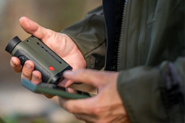 A man holds Leica Rangemaster CRF PRO in his hands