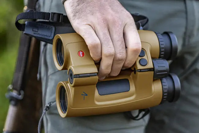 A hunter holds the Leica Geovid Pro 10x42 AB+ in their hand.