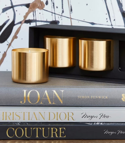 Gold candles on top of designer books