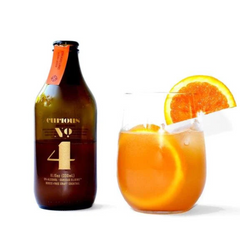 Bottle of Curious Elixir No. 4 and a glass with the orange cocktail in it 