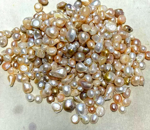 Trois ou quatre poignées de perles blanches, roses beiges, grises toutes avec des défauts majeurs, extensions dans tous les sens. poig