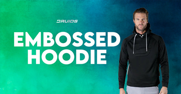 Druids Embossed Hoodie showcased by a model, a black hoodie with distinctive embossed branding, accompanied by white text 'EMBOSSED HOODIE' on a matching teal backdrop.