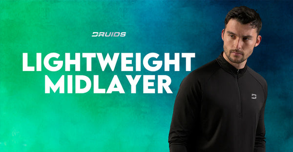 A male model wearing a black lightweight midlayer from Druids, with a half-zip neck and slim fit, the words 'LIGHTWEIGHT MIDLAYER' in white text overlay on a teal background.