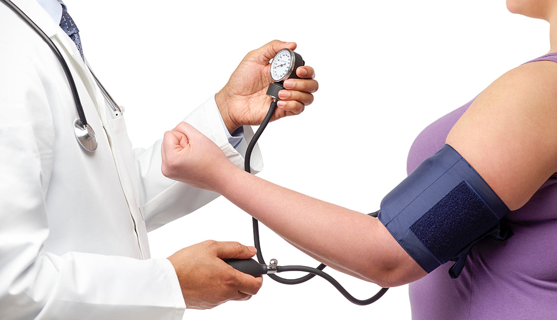 Doctor checking woman blood pressure