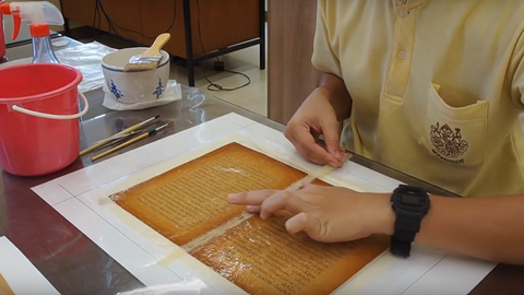 Reinforcing old book gutter using thin sheet of kozo paper