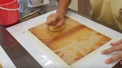 Using a sponge to remove any air bubbles on the now attached paper.