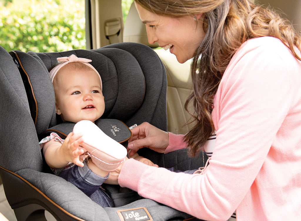 Mother buckles up the baby’s car seat