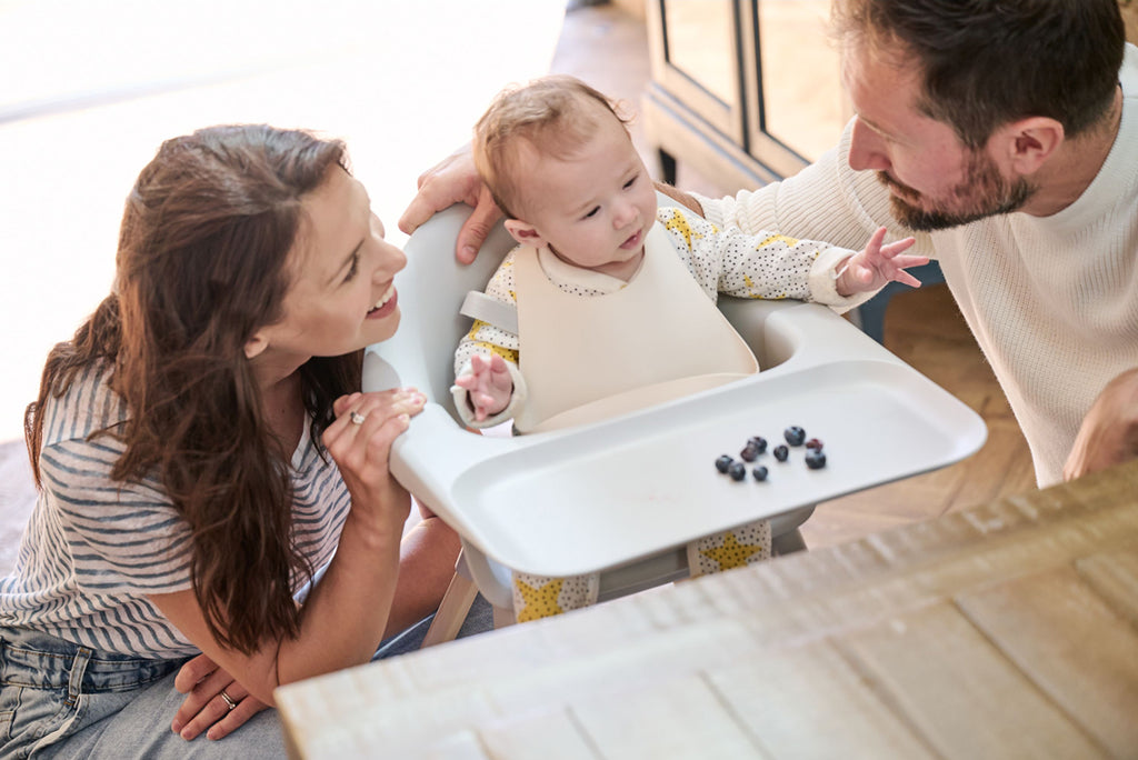 Mother and father are feeding their baby 