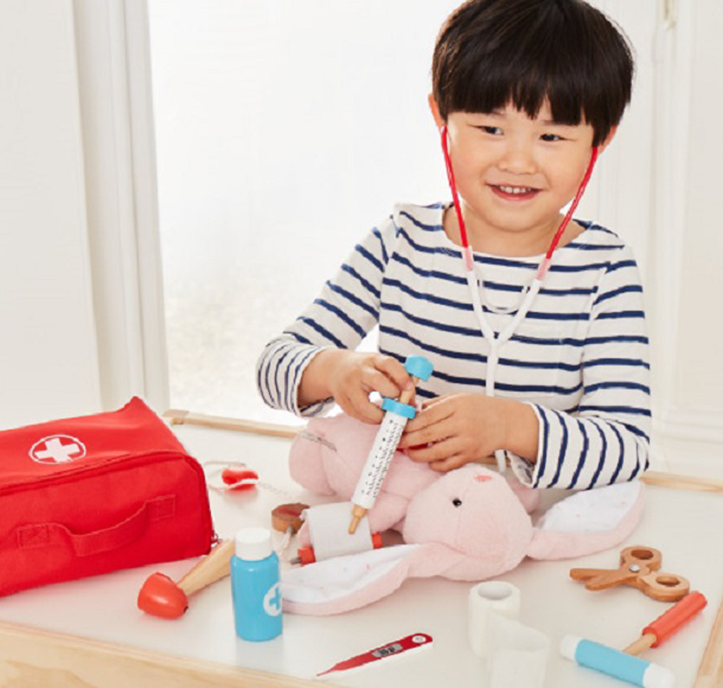 Little boy is playing with doctor pretend play set